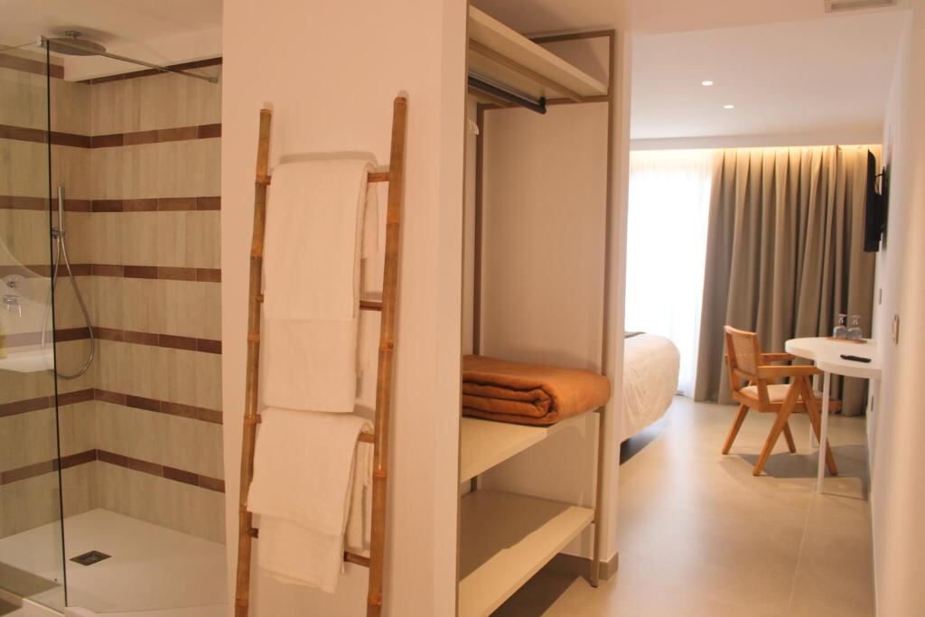 Walk-in shower, wardrobe and desk area inside a suite